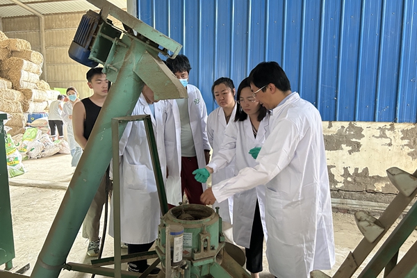 2d707ed1925141c6ba6ecd829267ecba.jpg 图二 指导老师杨雨鑫老师与队员参观饲料加工设备.jpg